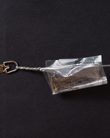 Wire hanger with plastic bag containing nail and hook screwed to back of framed Bryant Denny Stadium word art print.